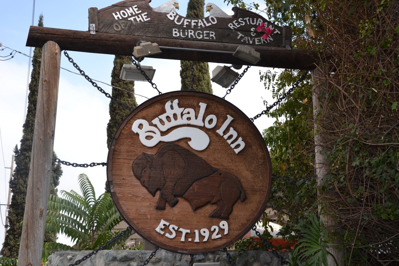 Rustic wooden sign for Buffalo Inn with a buffalo silhouette and establishment year 1927.