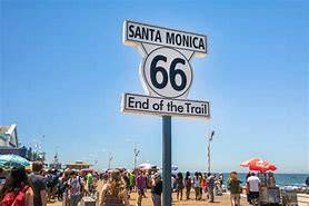 Santa Monica's Route 66 End of the Trail sign at a busy beach.
