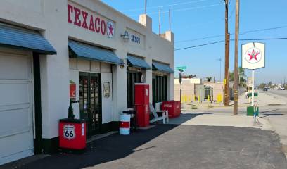 Vintage Texaco gas station with classic red pumps and signage.
