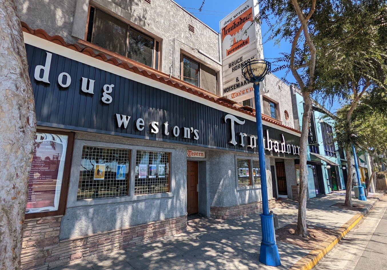 Rustic exterior of Doug Weston's Troubadour music venue on a sunny day.