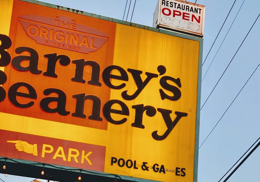 Partial signage of a restaurant named "Carney's" with words "OPEN", "PARK", and "POOL & GAMES" visible.