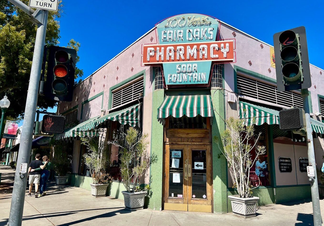 Vintage pharmacy storefront with colorful signage on a sunny day.