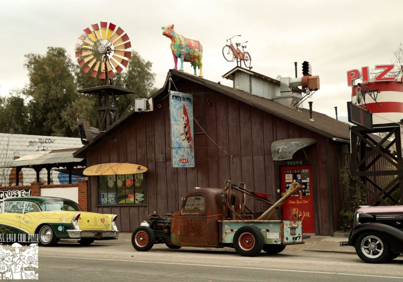 A rustic roadside shop with vintage decor and a whimsical animal statue on the roof.