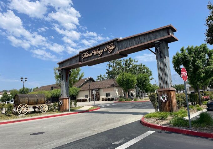 Entrance archway to Hidden Valley RV Resort under a bright sky.