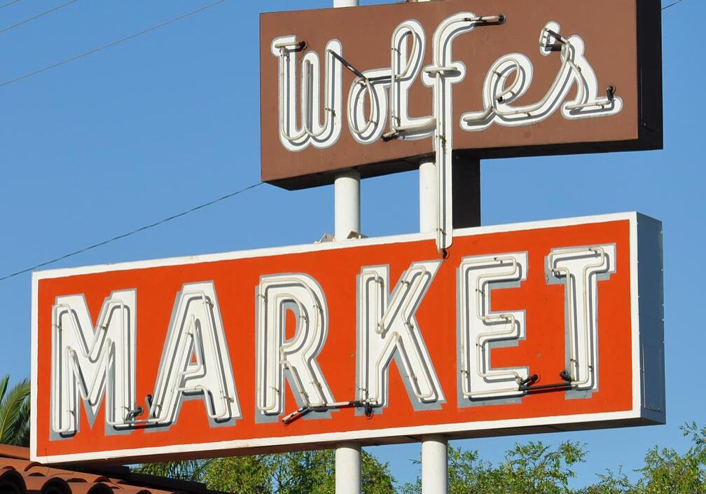 Vintage Wolfe's Market sign against a clear blue sky.