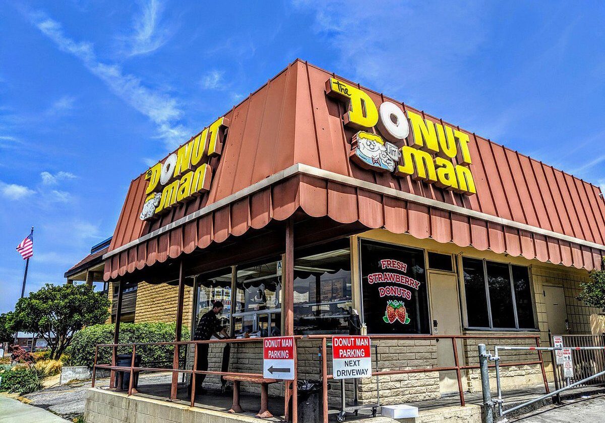 Exterior view of Donut Man shop with clear blue sky.