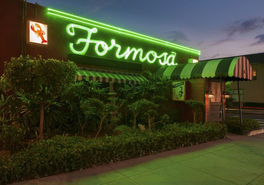 Neon sign reading 'Formosa' glowing green at night.