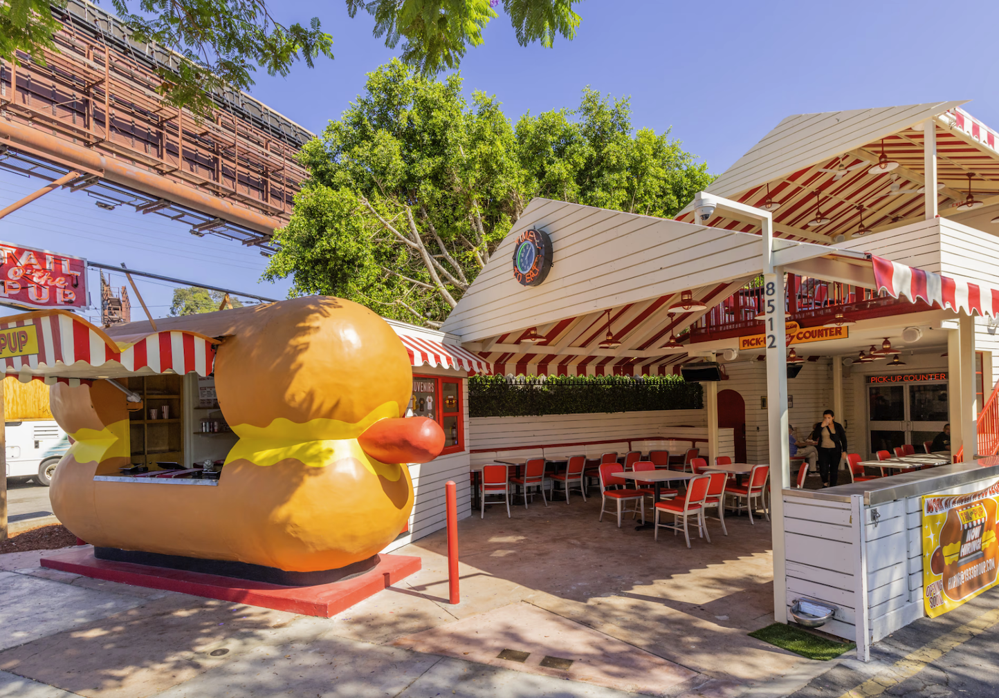 Outdoor dining area with a giant yellow duck sculpture.