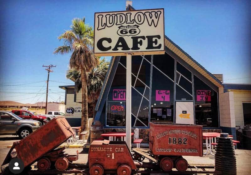 Rustic roadside cafe with vintage decor and toy trains outside.